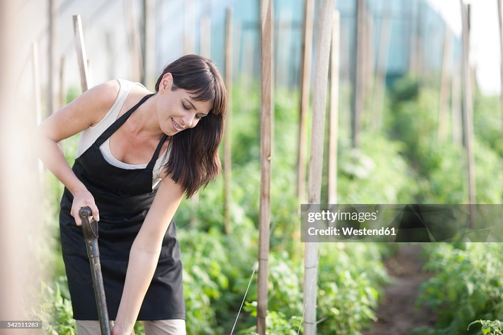 Woman digging on field