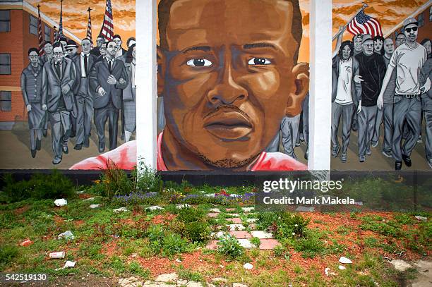 Trash collects below a mural of Freddie Gray after Baltimore police officer Caesar Goodson Jr. Was found not guilty on all charges on June 23, 2016...