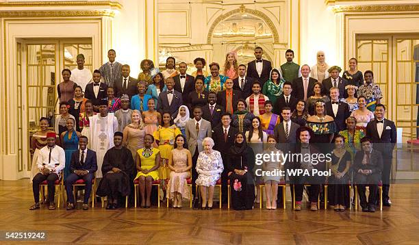 Queen Elizabeth II sits for a group photo with the sixty winners of the Queen's Young Leaders Awards at Buckingham Palace in London. Front row left...