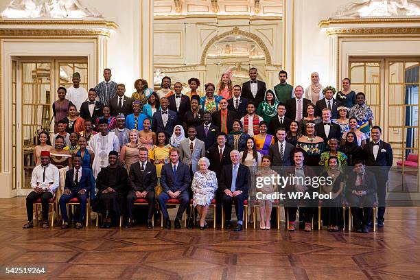 Queen Elizabeth II and Prince Harry sit for a group photo with guests David Beckham and Sir John Major and the sixty winners of the Queen's Young...