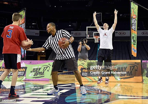 Cody Zeller of the Charlotte Hornets reacts as Camden Johnson makes a halfcourt shot during tryouts for the "Triple Shot Challenge: Kids' Choice...