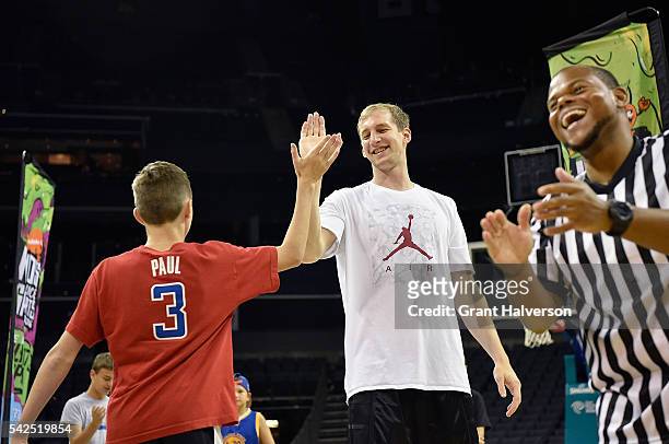Cody Zeller of the Charlotte Hornets congratulates Camden Johnson after Johnson sank a halfcourt shot during tryouts for the "Triple Shot Challenge:...