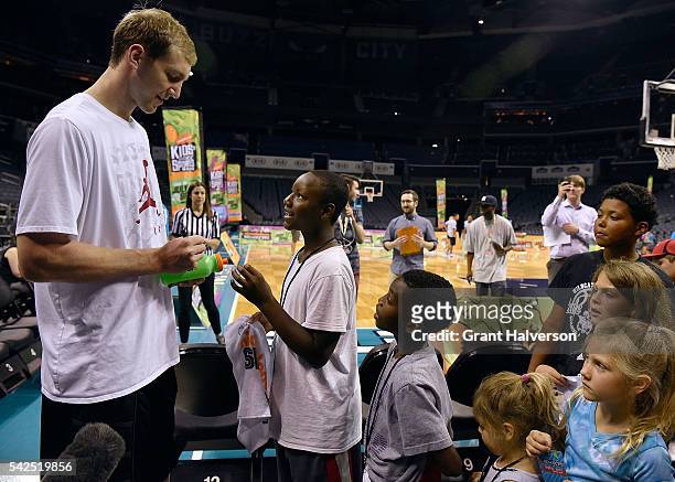 Cody Zeller of the Charlotte Hornets signs autographs and poses for pictures during tryouts for the "Triple Shot Challenge: Kids' Choice Sports...