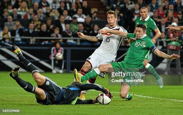 October 2014; Germany goalkeeper Manuel Neuer, aided by team-mate Erik Durm, saves the ball before the Republic of Ireland's Robbie Keane can connect...