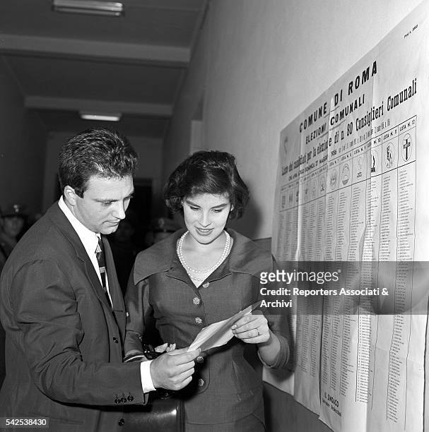 Italian actress Antonella Lualdi and her husband, Italian actor Franco Interlenghi, studying the lists for the election of the provincial council....
