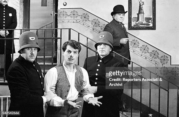 Italian actor Michele Placido held by two guards in The Black Hand. Behind him is American actor Lionel Stander as lieutenant Joe Petrosino. 1973