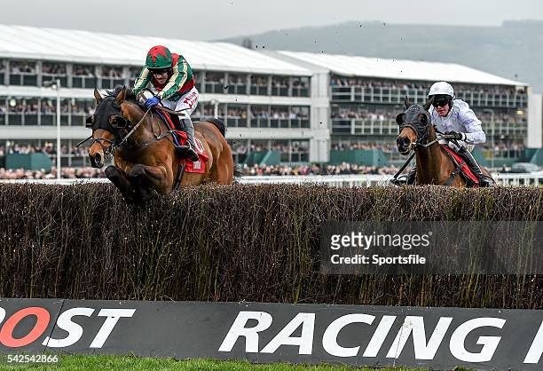 March 2016; Un Temps Pour Tout, left, with Tom Scudamore up, jumps the last ahead of Holywell, with Richie McLernon up, who finished second, on their...