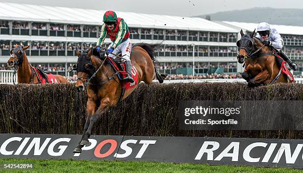 March 2016; Un Temps Pour Tout, left, with Tom Scudamore up, jumps the last ahead of Holywell, with Richie McLernon up, who finished second, on their...