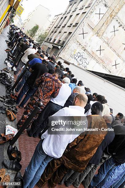 Muslims gather in Friday afternoon prayer in front of the Al Fath Mosque, a warehouse turned prayer site, in the Goutte d'Or district of Paris during...