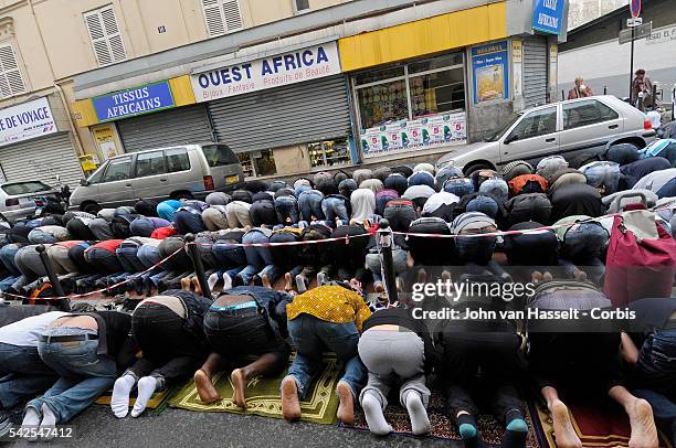 Muslims gather in Friday afternoon prayer in front of the Al Fath Mosque, a warehouse turned prayer site, in the Goutte d'Or district of Paris during...