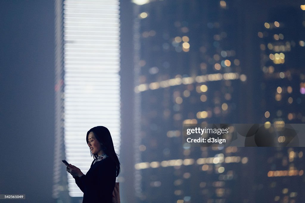 Businesswoman text messaging on smartphone in city