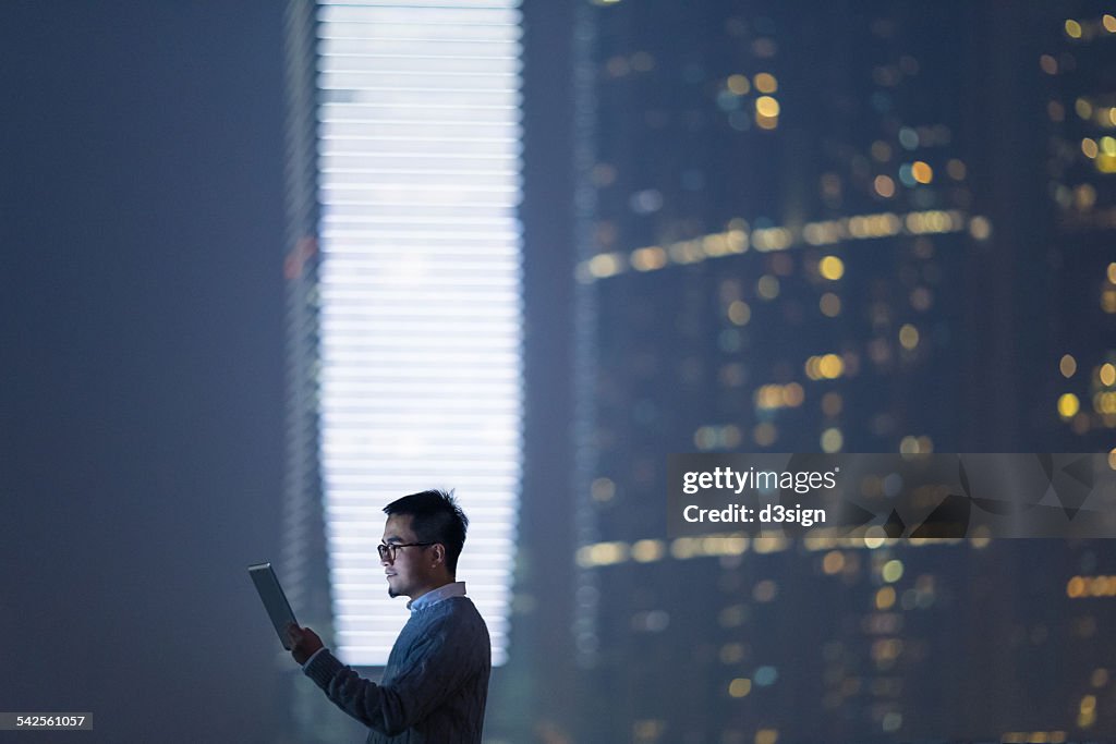 Smart businessman using digital tablet in city