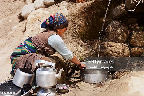 tibetan woman washing dishes. mustang, nepal - lo manthang stock pictures, royalty-free photos & images