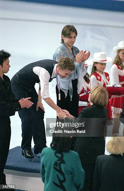 First place winner Timothy Goebel of the USA moves to shake hands with official as second place winner Takeshi Honda of Japan and third place winner...