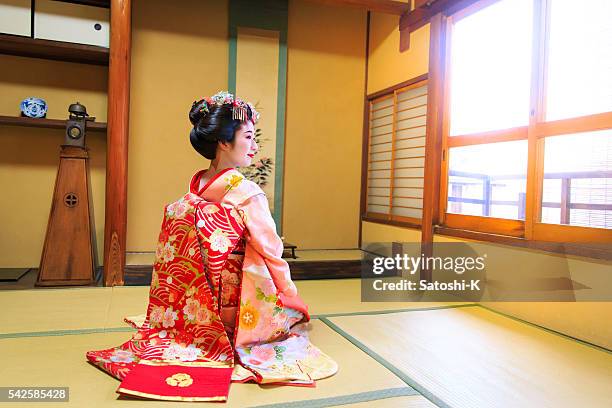 young maiko girl sitting in japanese tatami room with smile - geisha in training stock pictures, royalty-free photos & images