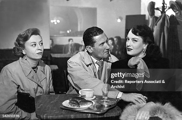 Italian actor Paolo Stoppa, Italian actress Giulietta Masina and Greek-Italian actress Yvonne Sanson sitting in a café in The Shameless Sex. 1952