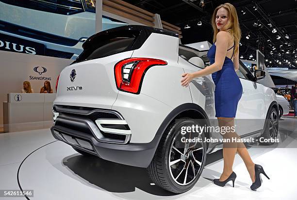 Hostess at the Ssang Yong stand poses with XIV concept car which will go on sale next year. World's largest automobile exposition, the 2014 Paris...