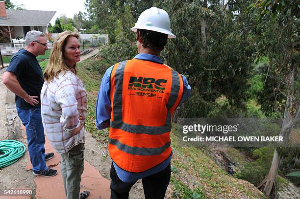 Ventura residents Mike Van Atta and Kelley Atwater talk with Josh Shankle, of National Response Company, about the cleanup procedure of 700 barrels...