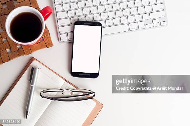 office table top view shot with the computer keyboard and mobile phone on desk cluttered with documents - office still life stock pictures, royalty-free photos & images