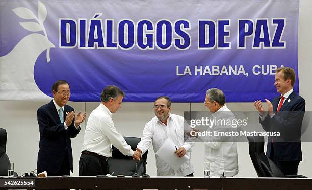 Timoleon Jimenez "Timonchenko" and Colombian President Juan Manuel Santos shake hands as Cuban President Raul Castro and Ban Ki-moon Secretary...