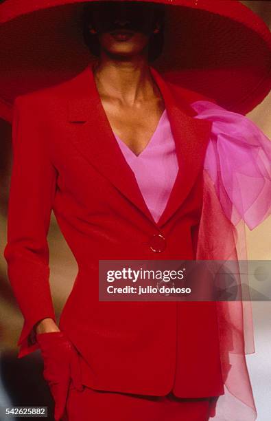 French design house Christian Dior shows its 1991 women's spring-summer haute couture line. The model is wearing a bright red suit with a large...