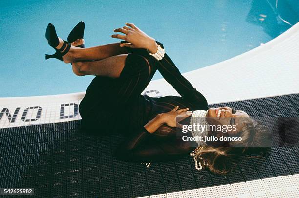 British top model Naomi Campbell laughs as she lies next to the pool at the Peninsula Hotel's club on New York's Fifth Avenue. Her dress is designed...