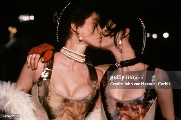 Models kiss as they wear outfits during a fashion show by British designer Vivienne Westwood.