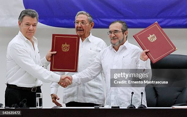 Juan Manuel Santos president of Colombia and Timoleon Jimenez "Timonchenko" shake hands shake hands during a ceremony to sign a historic ceasefire...
