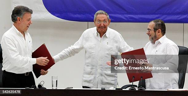 Juan Manuel Santos president of Colombia and Timoleon Jimenez "Timonchenko" shake hands shake hands during a ceremony to sign a historic ceasefire...