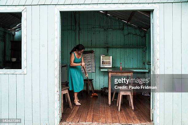 Woman sweeps the floor of a little restaurant in Boca do Acre. Amazon, Brazil, April 8th 2011.