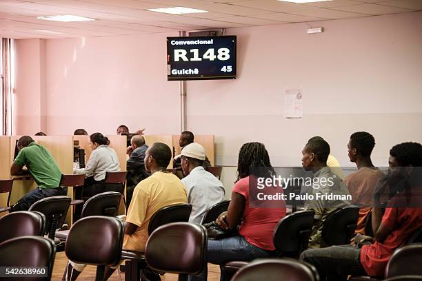 Refugees wait to fill in aplications for jobs at People wait on line to get service for jobs and unemployement insurance at CAT Centro de Apoio ao...