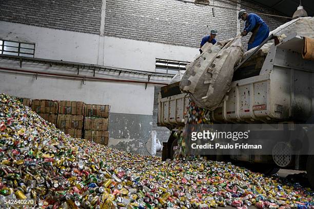 Worker unloads aluminium cans from a truck at the Latasa Reciclagem SA collection center in Pindamonhangaba, Brazil, on Wednesday, Nov. 4, 2015.