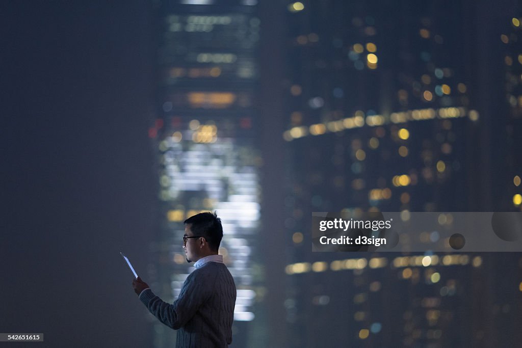 Smart businessman using digital tablet in city