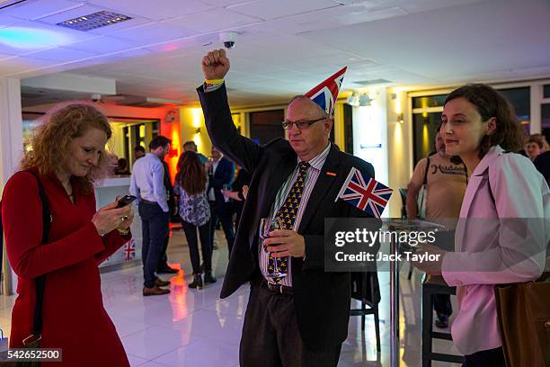 Man wearing a Union Jack hat does a dance as he watches the EU referendum coverage at the Leave.EU campaign's referendum party at Millbank Tower on...