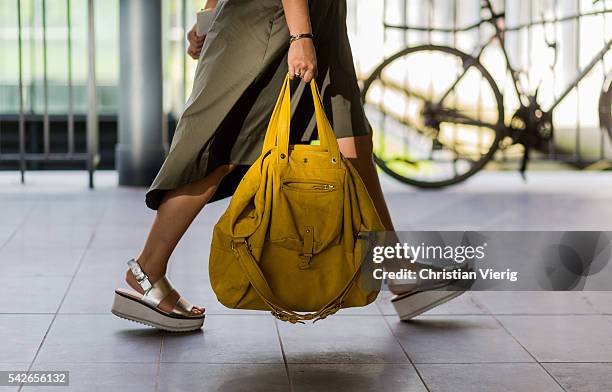 Guest wearing a yellow bag and platform sandals outside Issey Miyake during the Paris Fashion Week Menswear Spring/Summer 2017 on June 23, 2016 in...