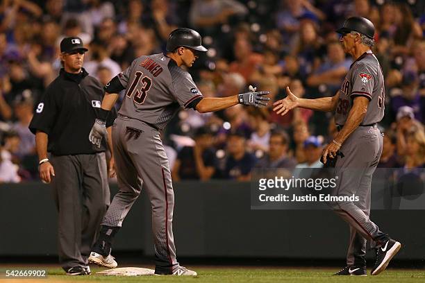 Nick Ahmed of the Arizona Diamondbacks gets a handshake from first base coach Dave McKay after hitting a go-ahead RBI single during the ninth inning...