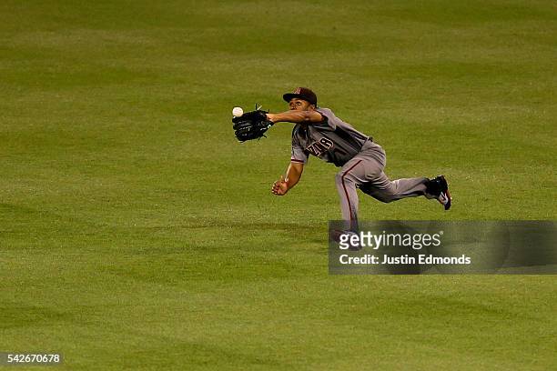 Center fielder Michael Bourn of the Arizona Diamondbacks makes a diving catch for the second out of the ninth inning against the Colorado Rockies at...