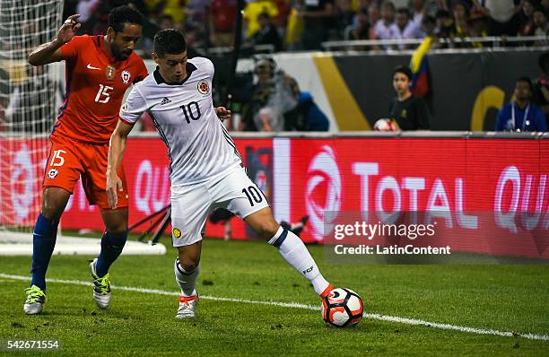 James Rodriguez of Colombia fights for the ball with Jean Beausejour of Chile during a Semifinal match between Colombia and Chile at Soldier Field as...