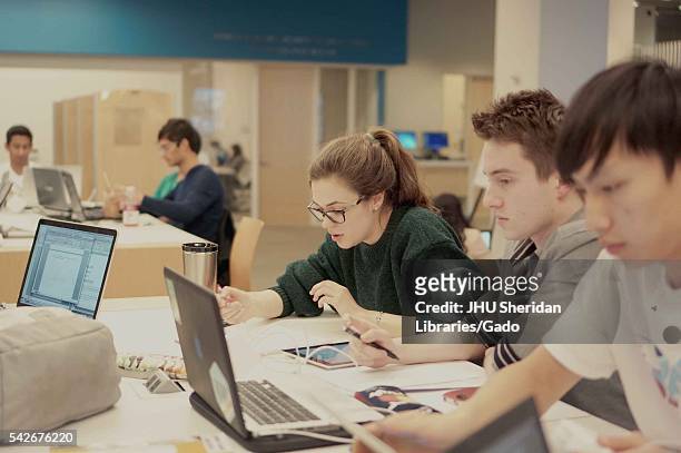 College students sit at a table studying in the Brody Learning Commons, a interactive/collaborative study space and library on the Homewood campus of...