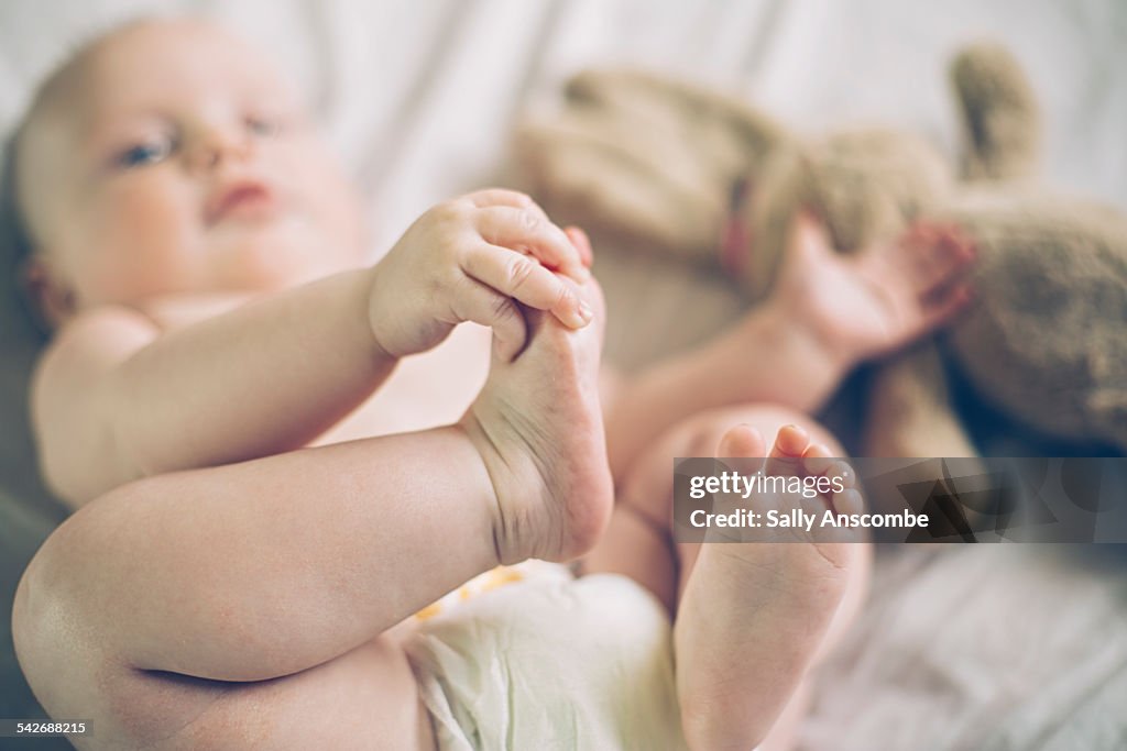 Baby girl holding her toes