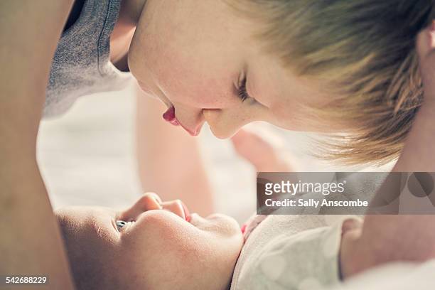 child giving his baby sister a kiss - kiss sisters foto e immagini stock
