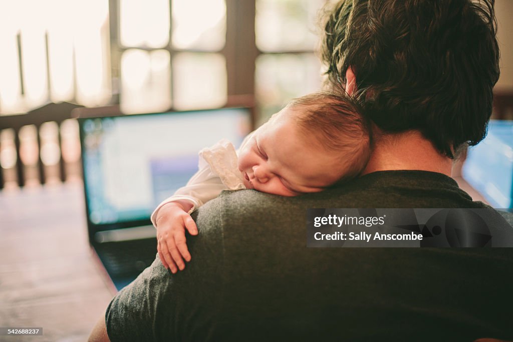 Baby asleep on fathers shoulder