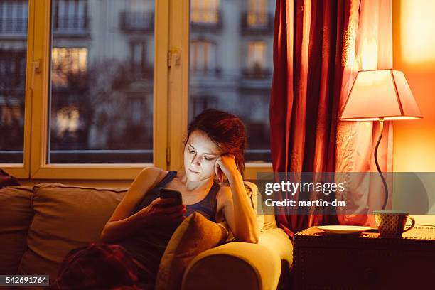woman at home texting on phone - an unforgettable evening stock pictures, royalty-free photos & images
