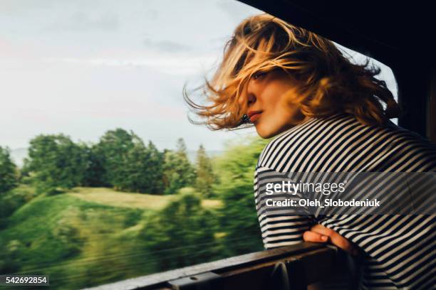 woman looking at the view from train - raam stockfoto's en -beelden