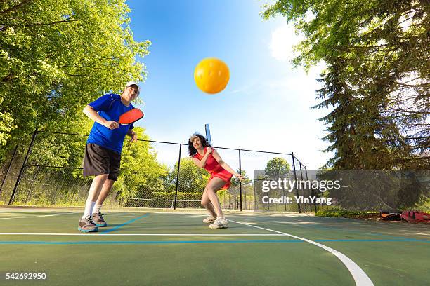 adult man and woman pickleball player playing pickleball in court - table tennis bat stock pictures, royalty-free photos & images