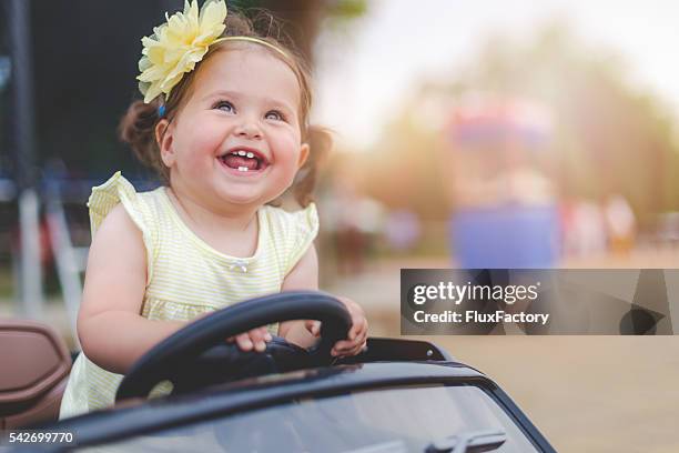 menina bebê bonito em carro de brinquedo elétrico - toy drive - fotografias e filmes do acervo