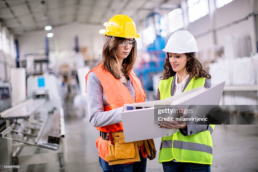 Two girls working together in factory