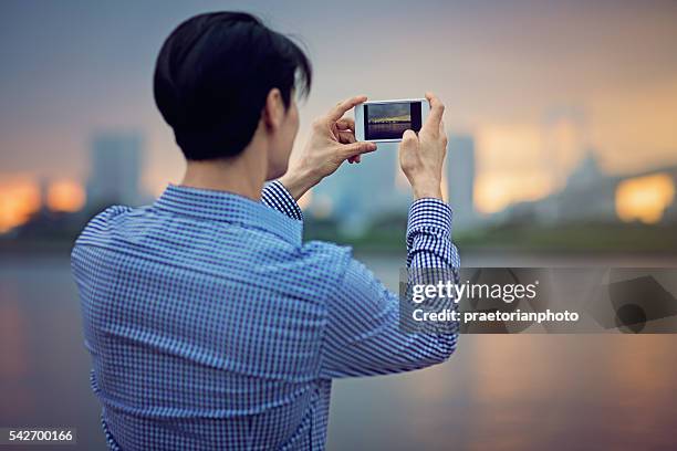 young japanese man is taking photo - capturing an image stock pictures, royalty-free photos & images