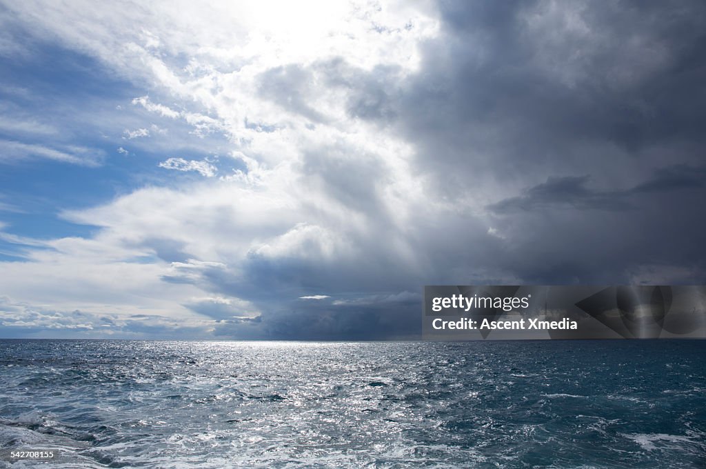Storm clouds pass above sea, sunlight returns