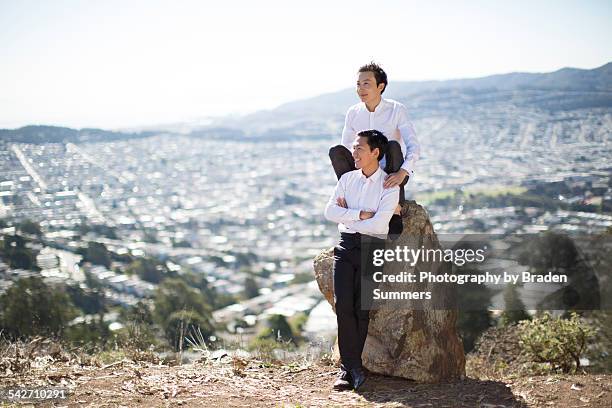 gay couple in looking out over city view. - looking backwards stock pictures, royalty-free photos & images